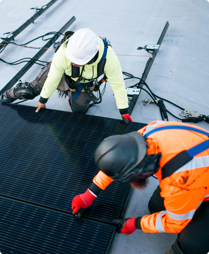 Workers installing solar panels on roof