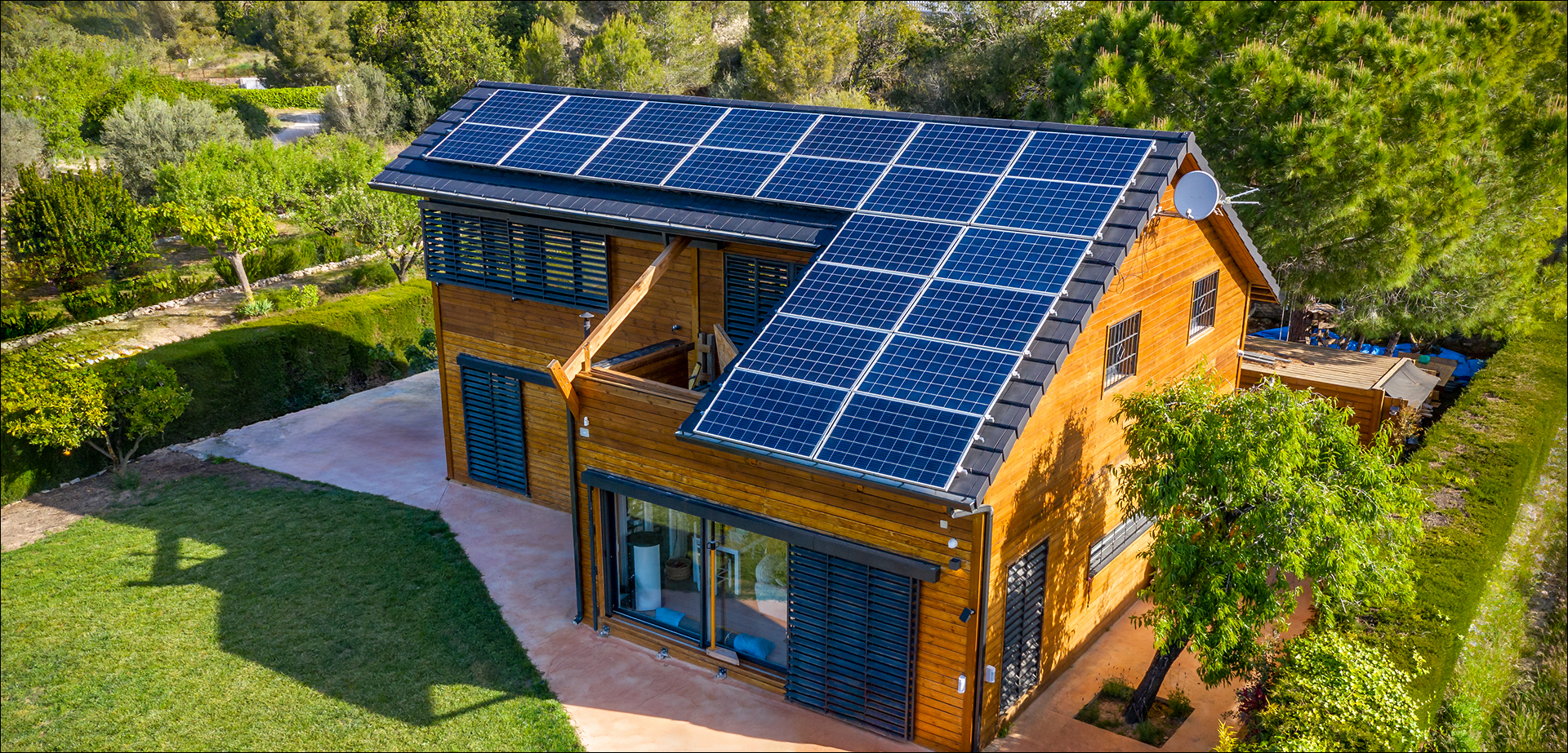 Modern wooden house with solar panels on the roof.