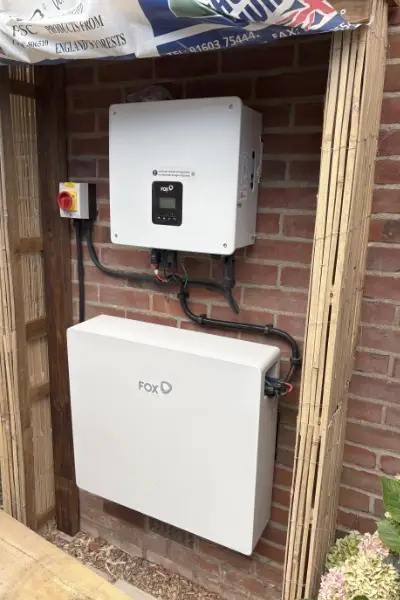 Fox ESS battery storage system and inverter installed on an exterior brick wall.