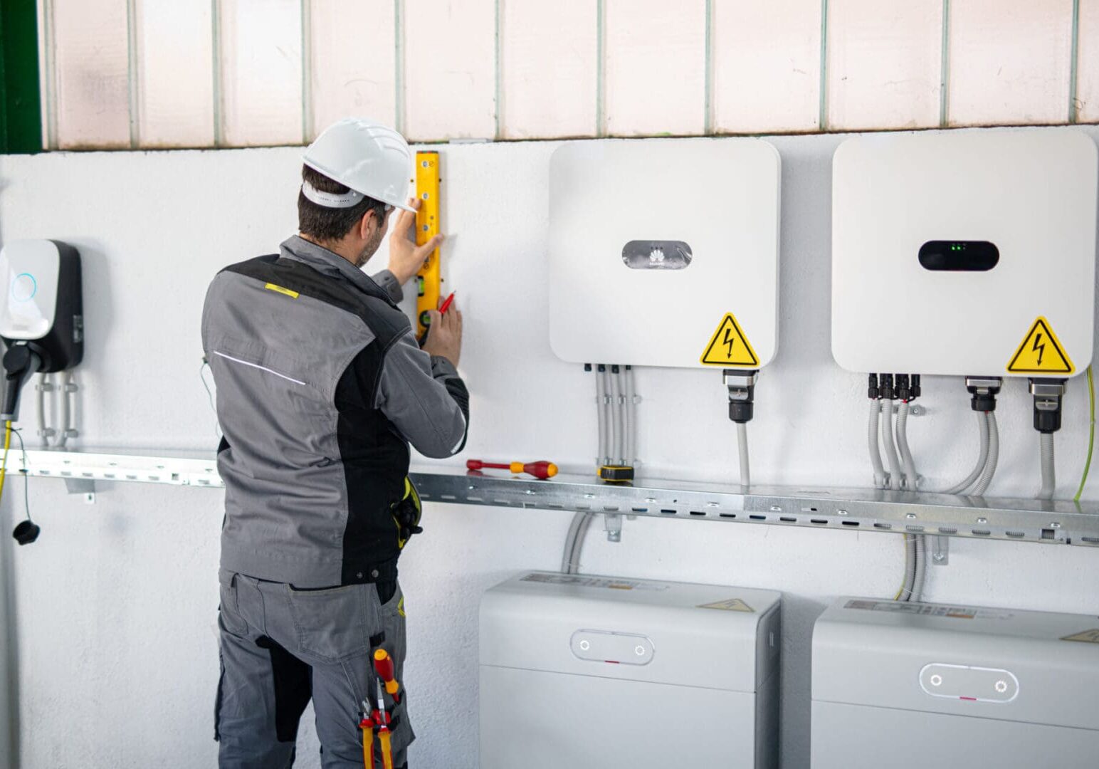 Electrician working on an electrical panel with tools.